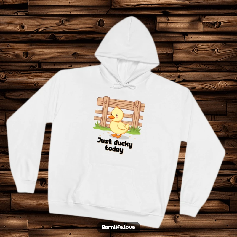 Funny duckling hoodie featuring a happy baby duck waddling near a wooden farm fence, providing warmth and adorable farm-themed cheer.